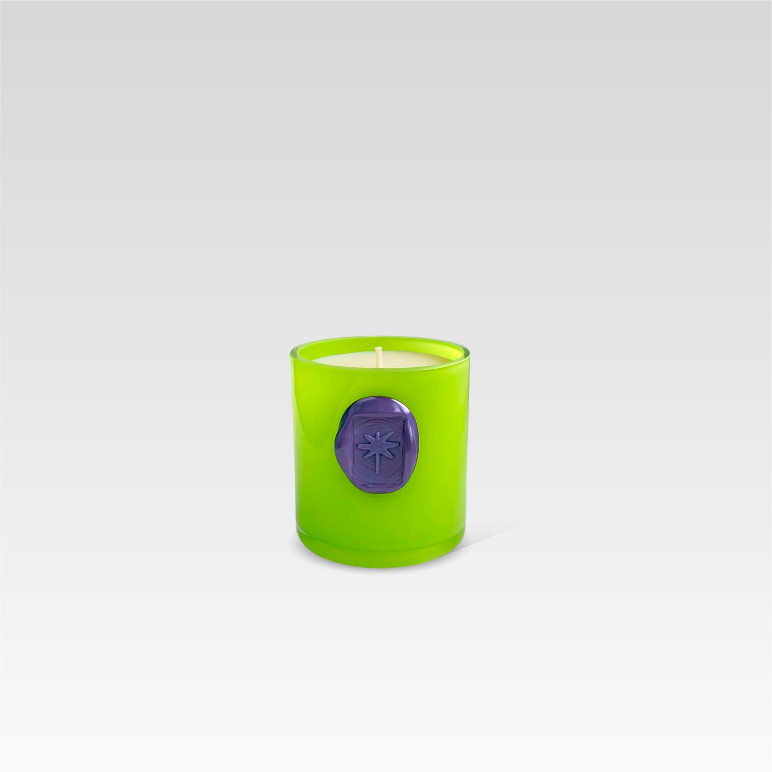 Green candle with a purple imprint stamp on a light gray background