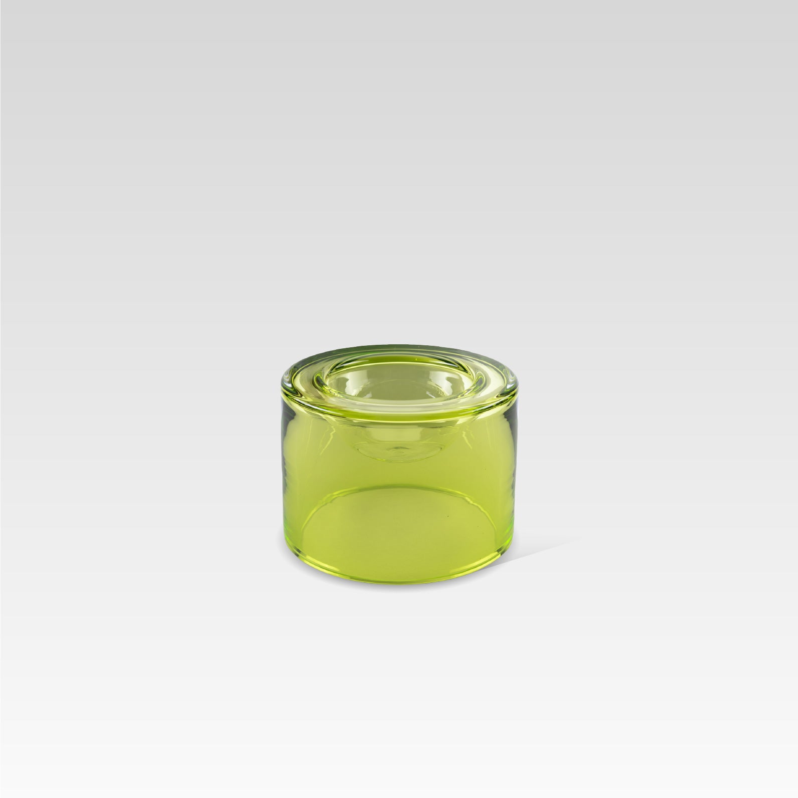 A high-green lime color glass wet bowl, positioned on a grey background