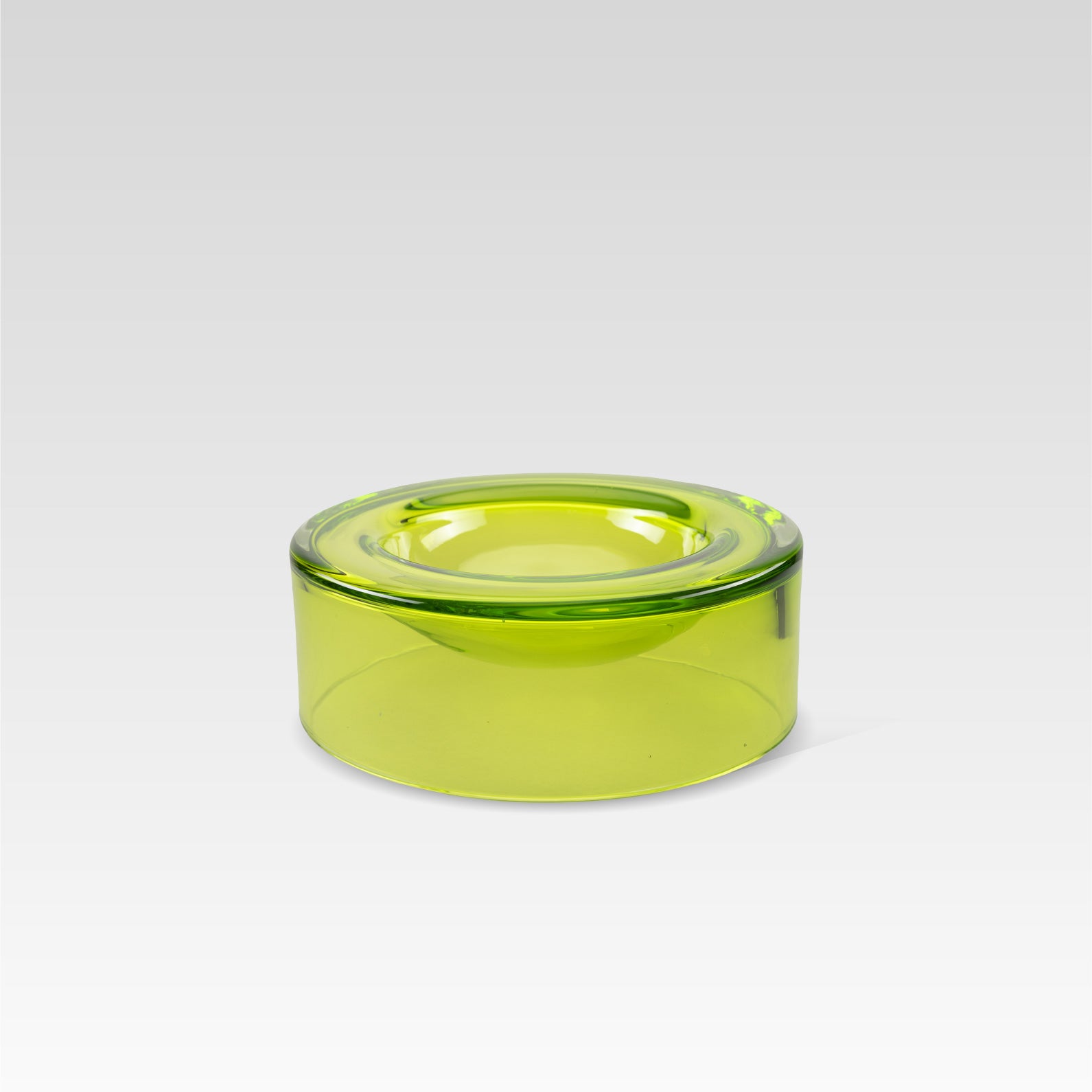 A medium-sized, lime green glass bowl designed to appear as if it is floating on the surface