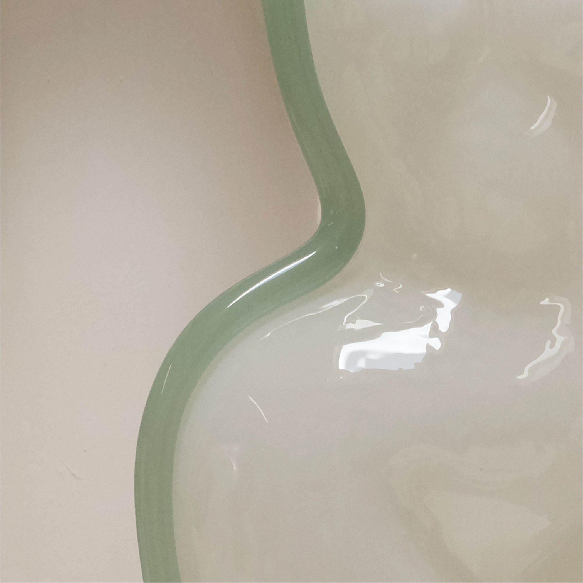 Closeup detailed photo of the white womans figure made of glass with a light glue/green stripe on the left