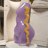 Purple glass sculpture with wavy orange accent in a workshop setting