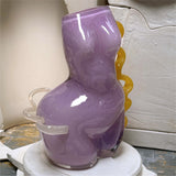 Purple glass vase with a textured surface on a white surface.
