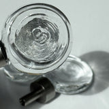Close up of the flux knob, with beautiful light and another flux knob visible in the background laying on a white surface and light shining through it.