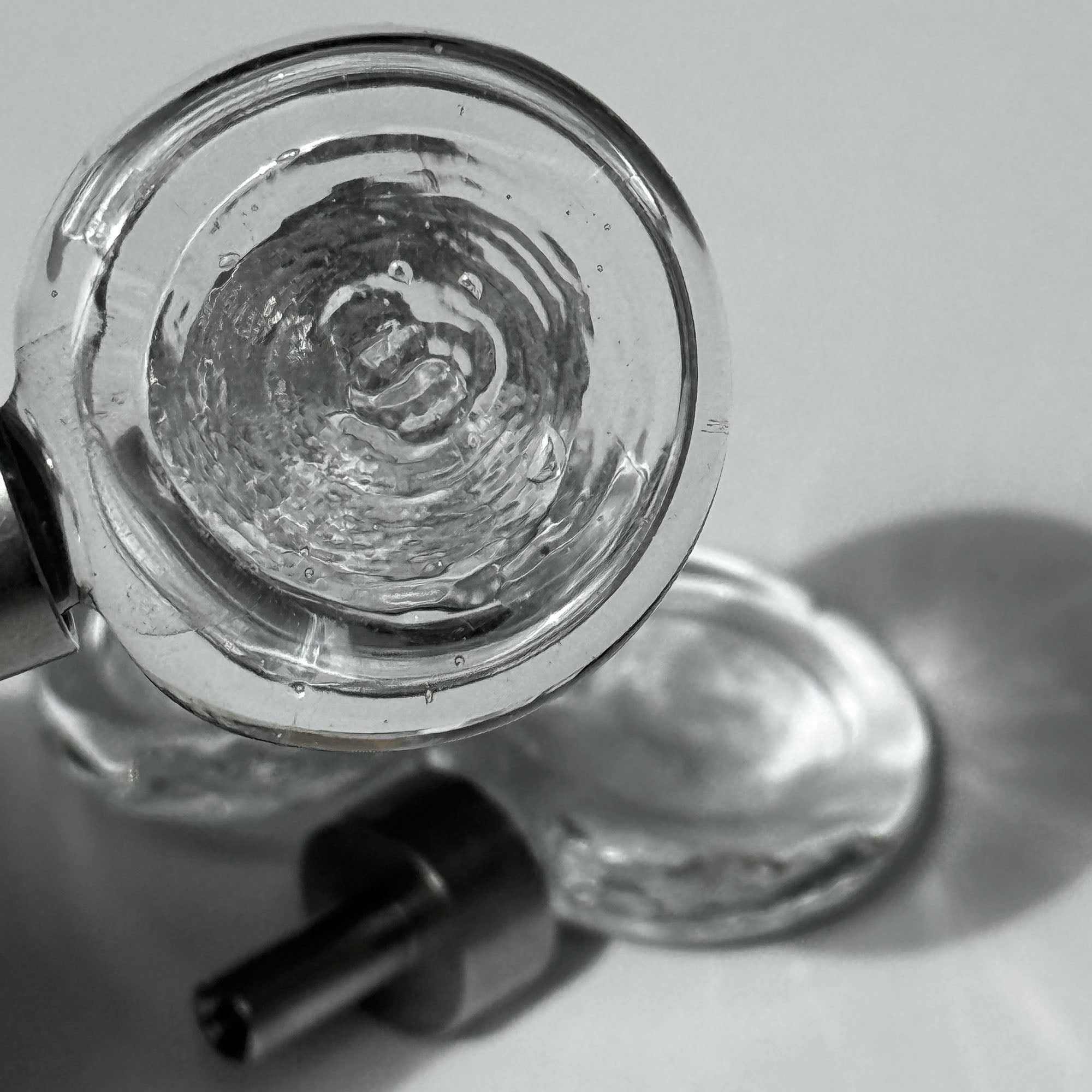 Close up of the flux knob, with beautiful light and another flux knob visible in the background laying on a white surface and light shining through it.