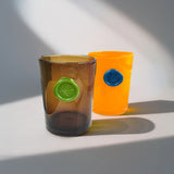 Two colored vases with circular imprint designs stamped on front of each, on a light background.