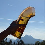 Hand holding a large Nessie Carafe against a mountainous landscape