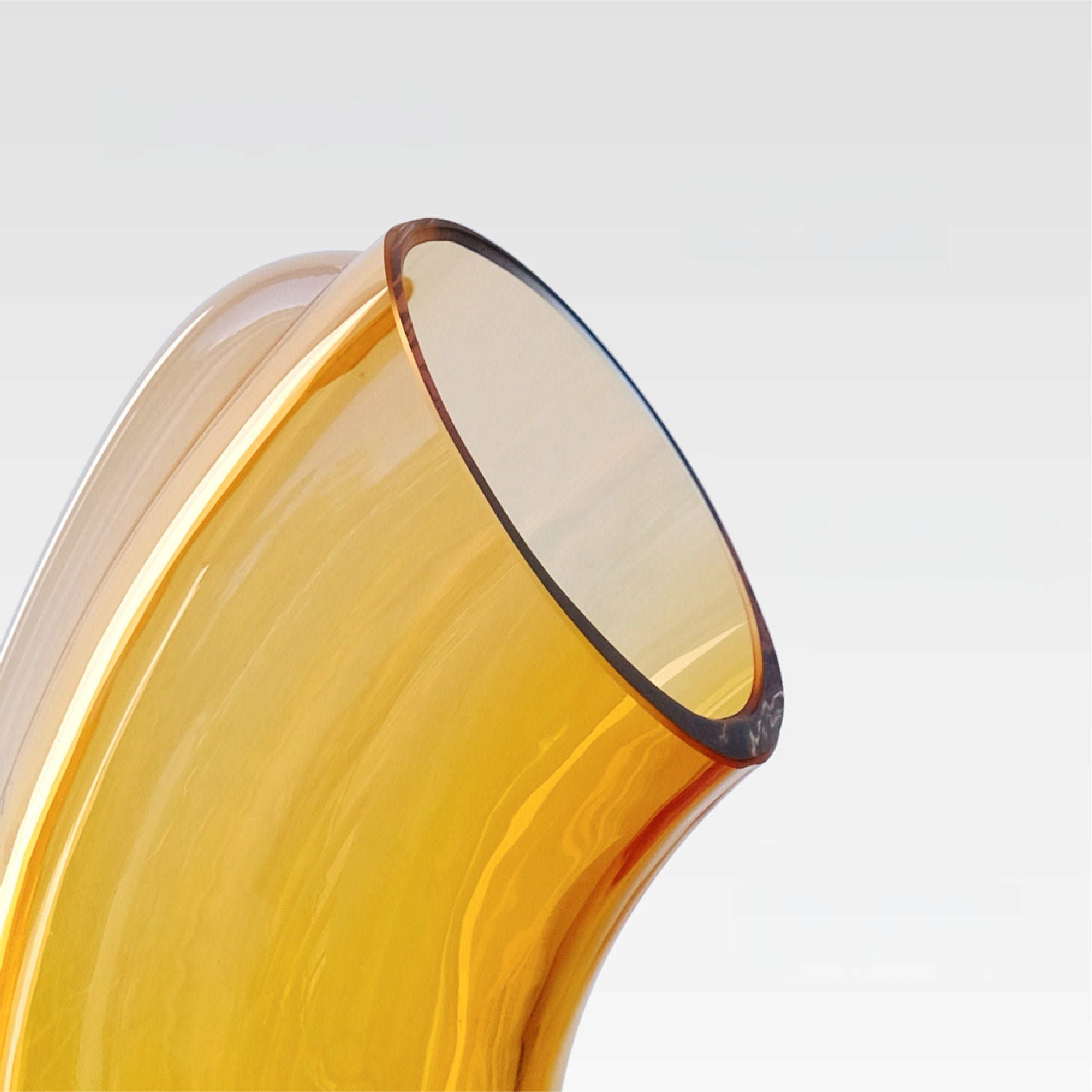 Close-up of an aurora light orange glass vase on a light gray background