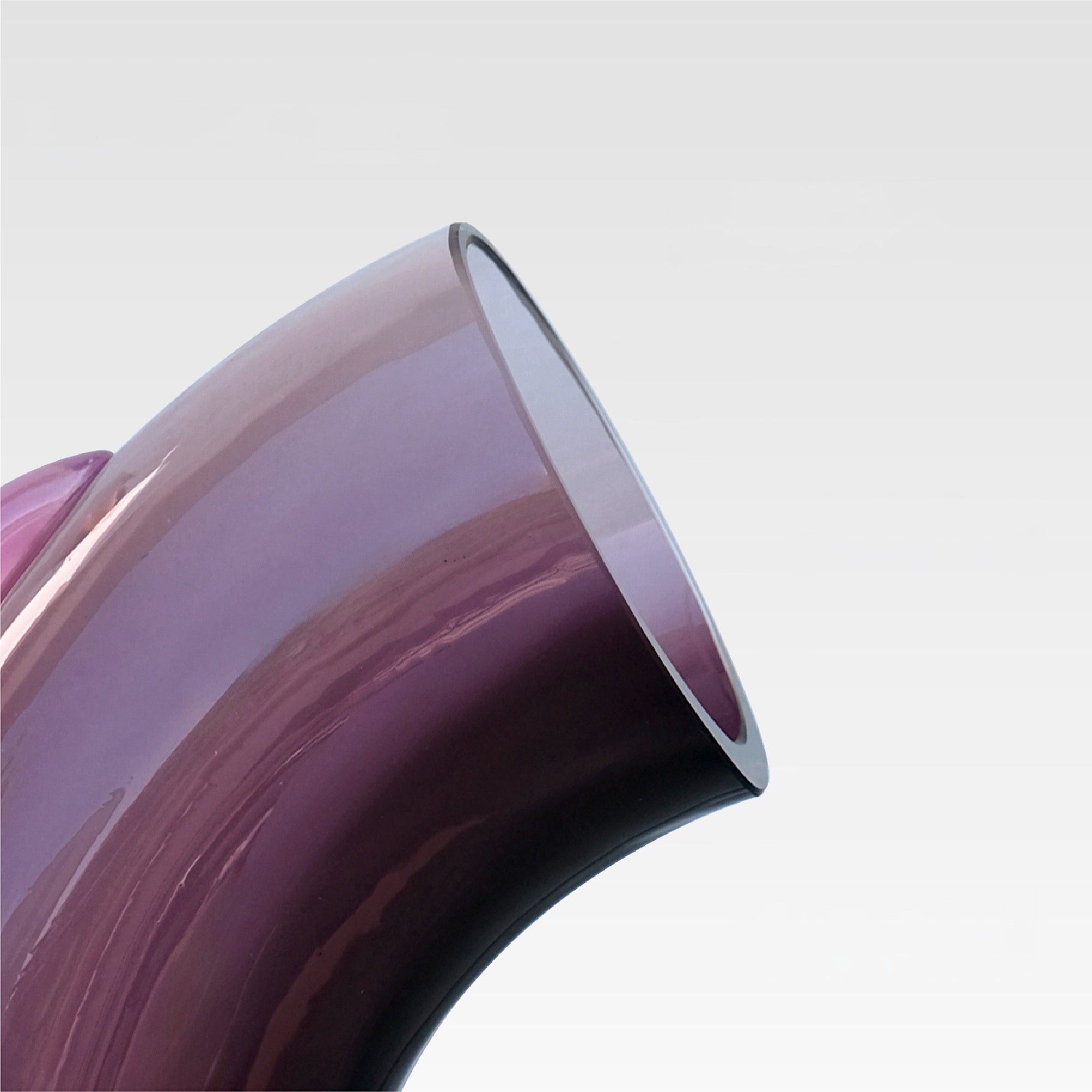 Close-up of a purple glass vase on a light gray background