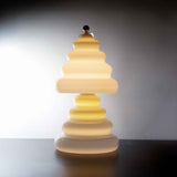 Pulsar vanilla lamp with a unique wavy design on a dark surface and light gray background.