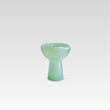 A green, glass decorative phantom dish with an irregular, organic shape, handmade and displaying possible magical bubbles or unique features.