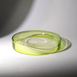 A translucent light green wetbowl glass, photographed on a white surface with a soft shadow.