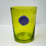 Green glass tumbler with a purple stamp imprint on a white background