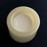 High vanilla bowl, filled with milk on a black background